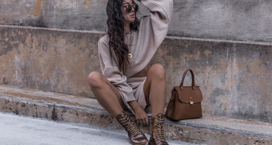 Kvinna i monokrom beige outfit med boots och brun handväska
